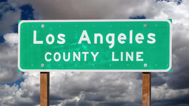 Los Angeles County Line sign with time lapse clouds.