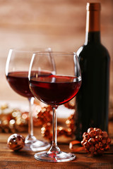Red wine and Christmas ornaments on wooden table on wooden background