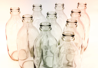 Detail of glass bottles on white background. Hint of red and blue color filter