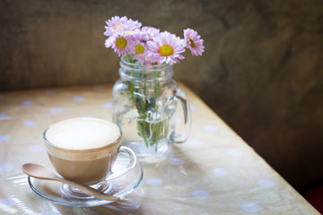 hot coffee and bouquet of flower on grunge wood table.