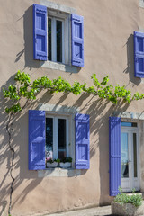 Lavender shutters on an old house facade in Provence, France.