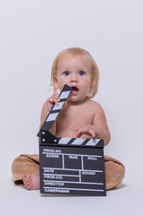 Boy sitting with a cinema clapperboard