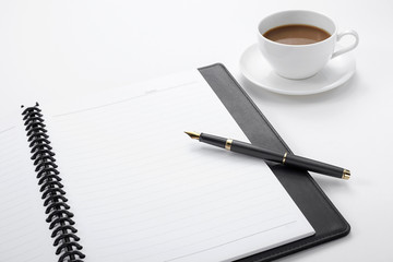 Notebook with a pen and a cup of coffee