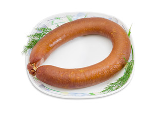 Sausage with branches of dill on a white dish