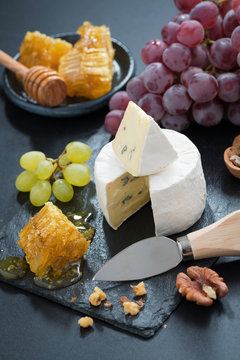 delicious Camembert with fresh honey, grapes and nuts, vertical