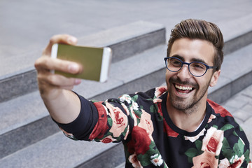 Young man taking self portrait with Smartphone