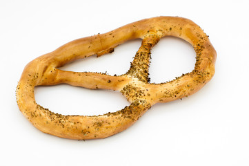 close-up of one pretzel, brown and covered with poppy seeds, on a white background