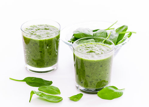 Two glass of green smoothie with spinach on white background, isolated