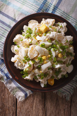 Traditional potato salad close-up on a plate. Vertical top view
