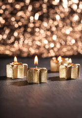 Brennende goldene Kerzen vor glitzerndem Bokeh Hintergrund, Weih
