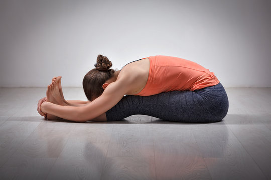Woman practices Ashtanga Vinyasa yoga asana