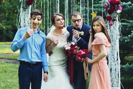 elegant stylish happy guests and bride and groom having funny ph