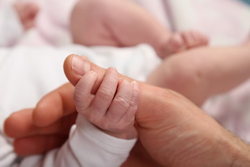 Baby h&auml;lt Papas Daumen