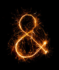 ampersand symbol  made of firework sparklers at night