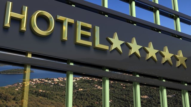 Metallic hotel sign board with five golden stars and island with seascape as background.