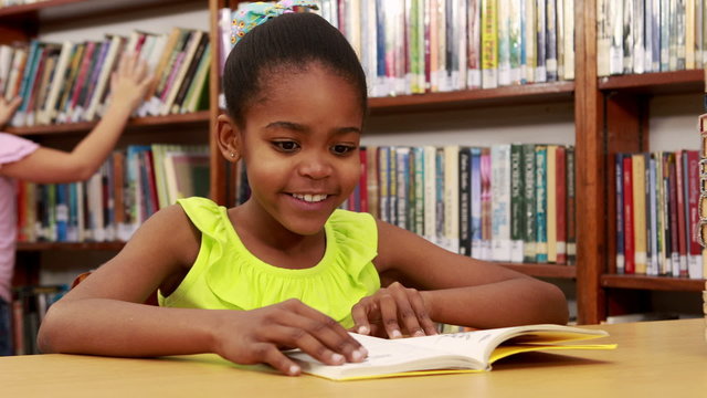 Smiling little girl reading a book