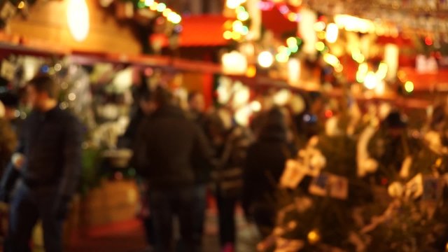 People visit  Christmas Fair in old town at evening. Defocused
