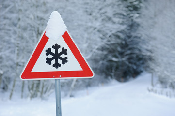 Verkehrsschild warnt vor Schneeglätte im Winter