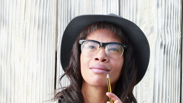 Smiling hipster woman with pencil