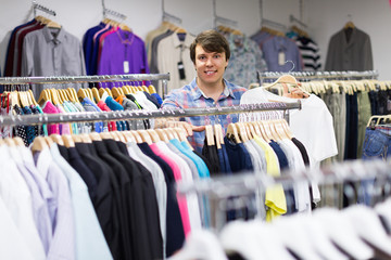 Fototapeta na wymiar Male choosing t-shirts in the shop