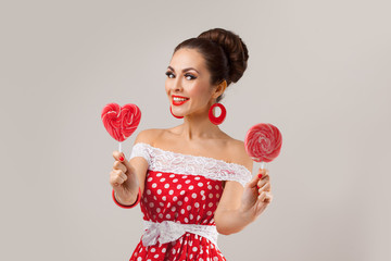  Happy Woman Holding Two Red Lollipops. Pin-up retro style.