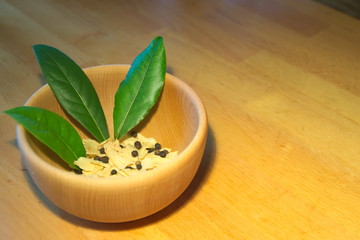 Bay leaves in wooden bowl with dry garlic and pepper 