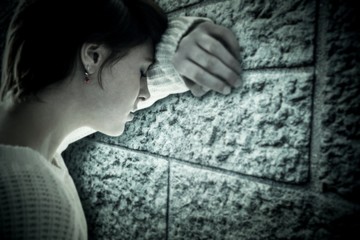 Composite image of sad pretty brunette leaning against wall