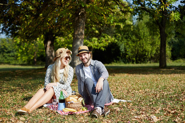 Young couple lying on the ground in the park and enjoying their