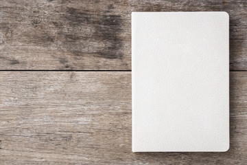 Top view of white book on old wooden plank