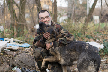 homeless man and her dog - obrazy, fototapety, plakaty