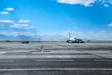 Aircraft standing on the airfield for maintenance, sunny blue sky