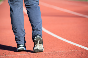 Fototapeta premium Athlete legs before jogging around the stadium, close-up view of feet in sport shoes, copy space