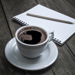 Notebook, pen and coffee on table