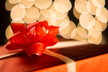 Red gift box on bokeh background. Soft focus.