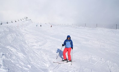 Fototapeta na wymiar Girl on ski track looking down to the slope