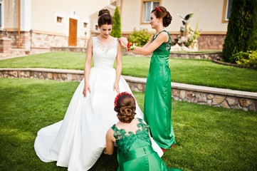 Bride in the courtyard of the mansion house with bridesmaids