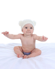 Portrait of adorable baby on the bed in the cap