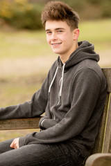 Obraz premium Teenage Boy Sitting on A Bench