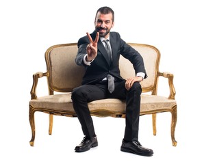 Businessman doing victory gesture