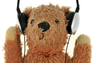 Ours en peluche écoutant de la musique avec un casque audio