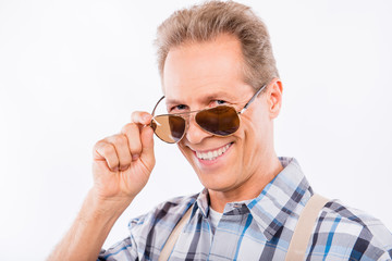 Happy aged man in suspenders holding glasses