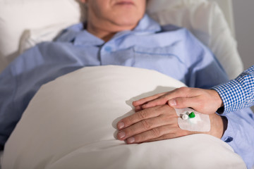 Obraz na płótnie Canvas Caregiver holding patient's hand