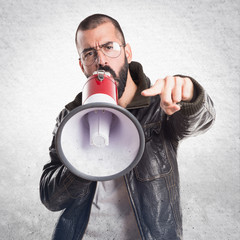 Man wearing a leather jacket shouting by megaphone
