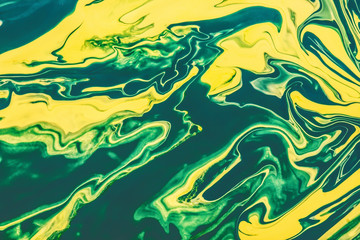 Yellow and green paint flowing and mixing texture.