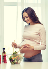 happy pregnant woman preparing food at home
