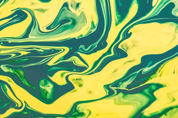 Fototapeta na wymiar Yellow and green paint flowing and mixing texture.