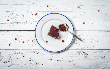 Chocolate cake with cream and fruit on retro wooden table