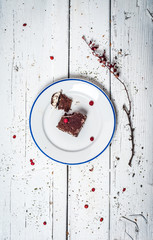 Chocolate cake with cream and fruit on retro wooden table