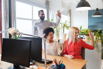 Obraz premium happy creative team waving hands in office