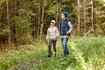 Naklejka na ściany i meble two happy kids walking along forest path